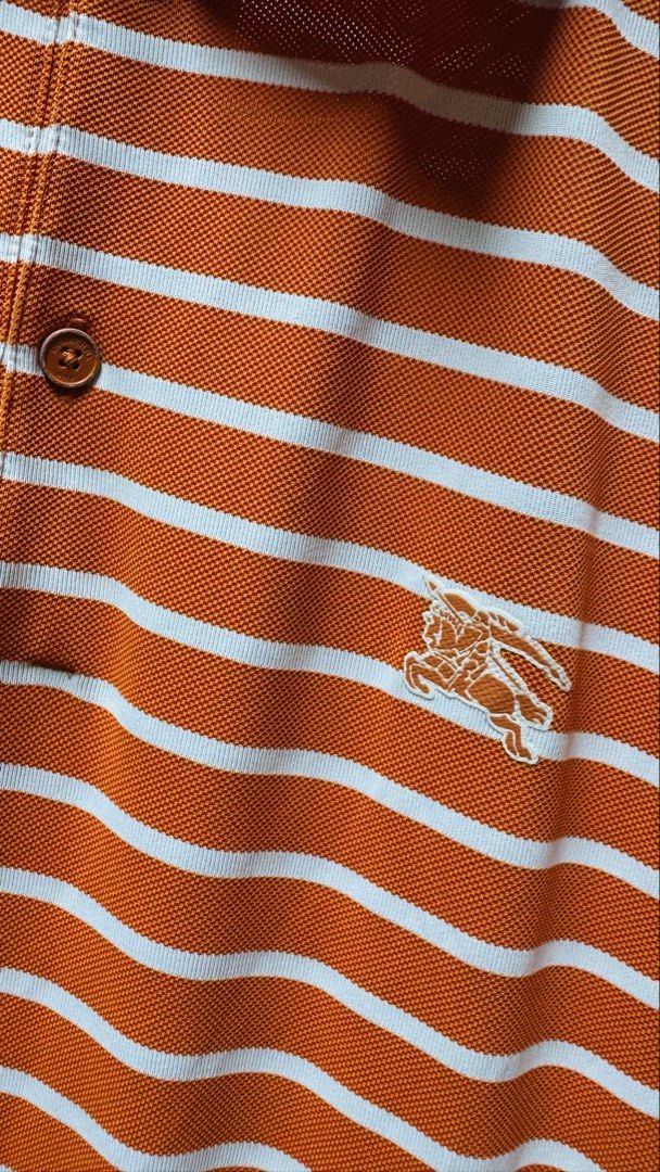 Authentic Burberry Golf Striped Polo Shirt (Category: Luxury Apparel) located in Batangas. Submitted by cjayf (Listing ID 1426640846, Image 2). Description: Orange and white striped polo shirt from Burberry Golf. Features the Burberry logo on the chest. The shirt has a collared neckline and short sleeves. Size 3. Made in Japan. Dimes 20x27.