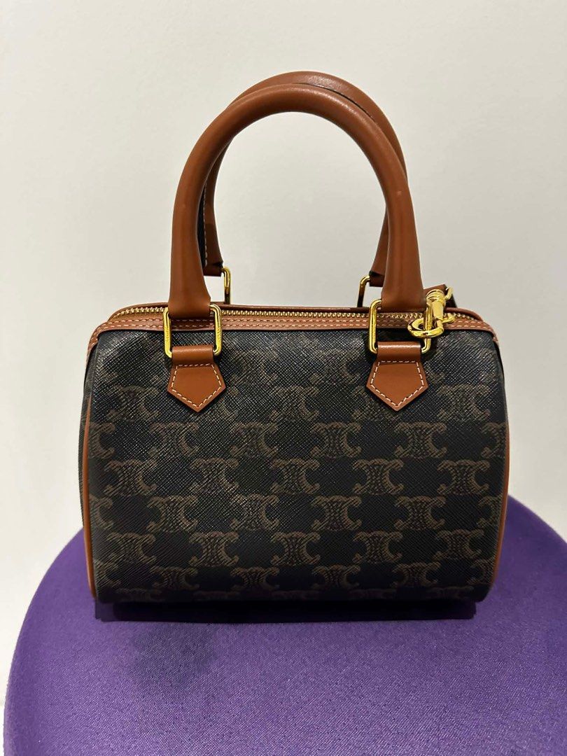 Celine Boston Bag (Category: Luxury Bags & Wallets) located in Paranaque City. Submitted by icollectbags (Listing ID 1426729499, Image 1). Description: Celine Boston bag with brown leather handles and trim. Features a zip closure with a gold-tone zipper and hardware. The interior is brown and includes a small pocket. The bag has a detachable strap. The exterior is printed with the Celine logo. Almost brand new! Please no low ballers.