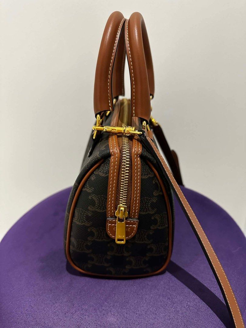 Celine Boston Bag (Category: Luxury Bags & Wallets) located in Paranaque City. Submitted by icollectbags (Listing ID 1426729499, Image 2). Description: Celine Boston bag with brown leather handles and trim. Features a zip closure with a gold-tone zipper and hardware. The interior is brown and includes a small pocket. The bag has a detachable strap. The exterior is printed with the Celine logo. Almost brand new! Please no low ballers.