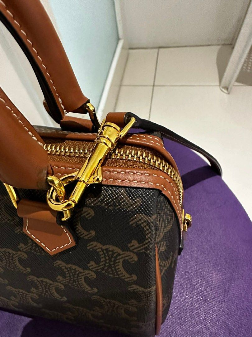 Celine Boston Bag (Category: Luxury Bags & Wallets) located in Paranaque City. Submitted by icollectbags (Listing ID 1426729499, Image 3). Description: Celine Boston bag with brown leather handles and trim. Features a zip closure with a gold-tone zipper and hardware. The interior is brown and includes a small pocket. The bag has a detachable strap. The exterior is printed with the Celine logo. Almost brand new! Please no low ballers.