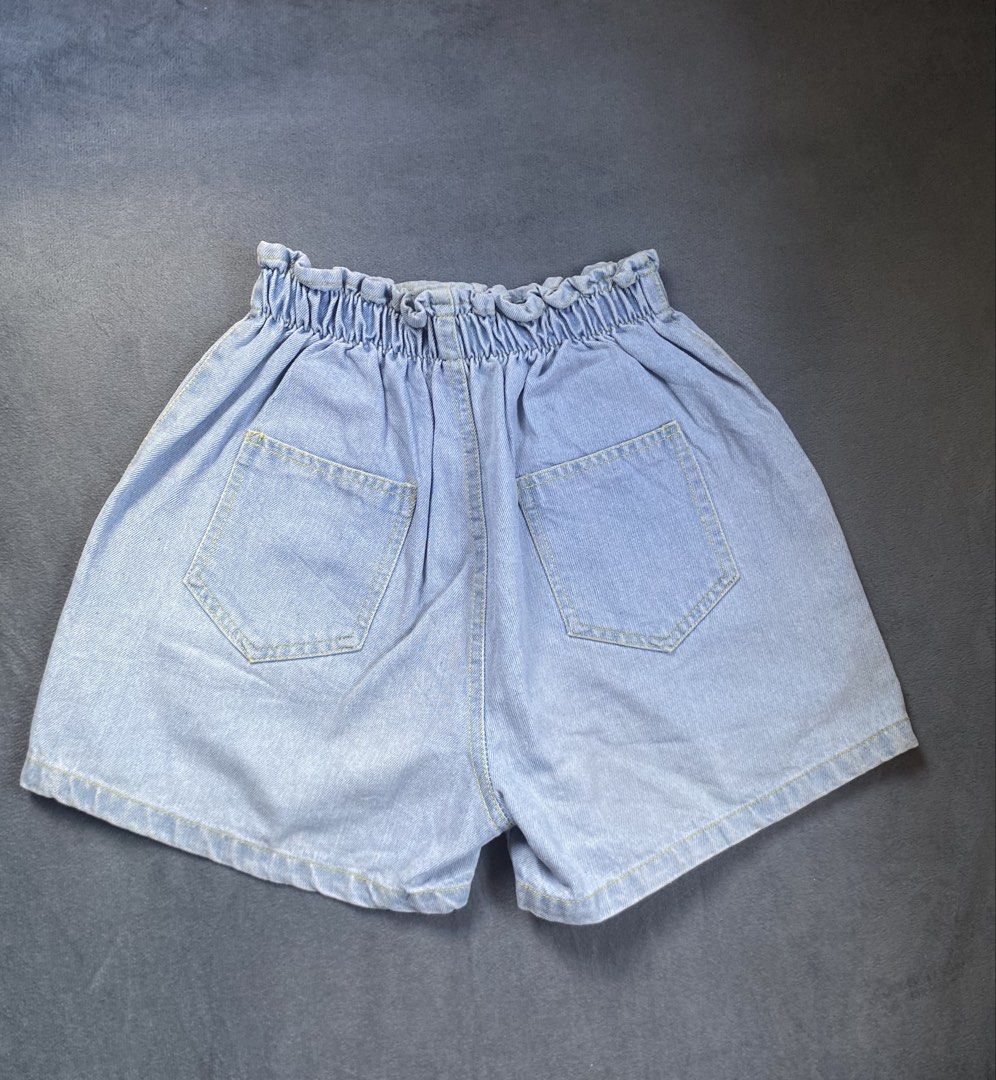 High-Waisted Denim Shorts Size 21-24 (Category: Shorts) located in Mamburao. Submitted by marieac (Listing ID 1426649005, Image 2). Description: These denim shorts feature a high-waisted design with an elastic waistband and button closure. They have two front pockets and two back pockets. The shorts are a light blue wash. They are perfect for casual wear and can be paired with various tops..