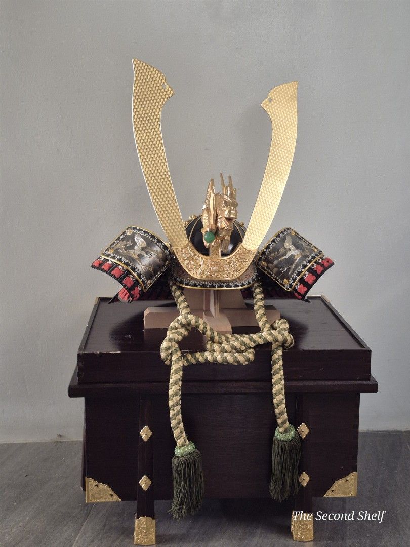 Japanese Samurai Helmet with Display Box (Category: Vintage Collectibles) located in Santa Rosa. Submitted by thesecondshelf (Listing ID 1426690936, Image 1). Description: Japanese Samurai helmet with intricate gold detailing and a display box. The helmet features a dragon motif and decorative elements. It includes a display box with gold corner accents and decorative rope. The helmet's gold elements have a textured pattern. The overall design su