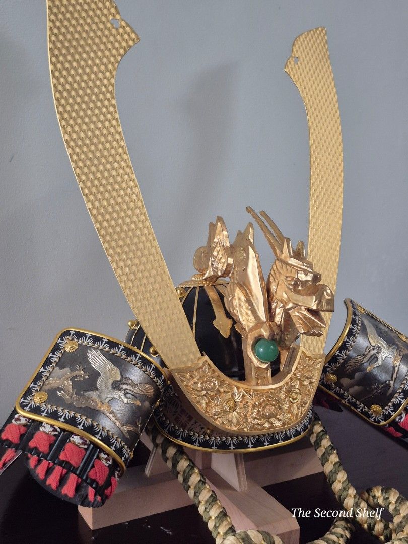 Japanese Samurai Helmet with Display Box (Category: Vintage Collectibles) located in Santa Rosa. Submitted by thesecondshelf (Listing ID 1426690936, Image 3). Description: Japanese Samurai helmet with intricate gold detailing and a display box. The helmet features a dragon motif and decorative elements. It includes a display box with gold corner accents and decorative rope. The helmet's gold elements have a textured pattern. The overall design su
