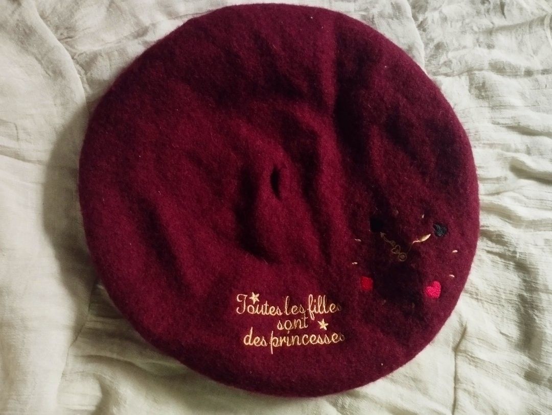 Maroon Embroidered Beret (Category: Hats & Beanies) located in Manila. Submitted by saphoo (Listing ID 1426647276, Image 1). Description: Maroon beret with embroidered design. Features the phrase "Toutes les filles sont des princesses" in gold thread, along with small embroidered hearts and other details. A stylish accessory for any outfit..