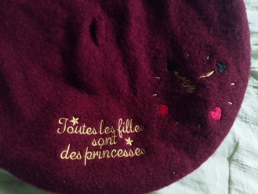 Maroon Embroidered Beret (Category: Hats & Beanies) located in Manila. Submitted by saphoo (Listing ID 1426647276, Image 2). Description: Maroon beret with embroidered design. Features the phrase "Toutes les filles sont des princesses" in gold thread, along with small embroidered hearts and other details. A stylish accessory for any outfit..