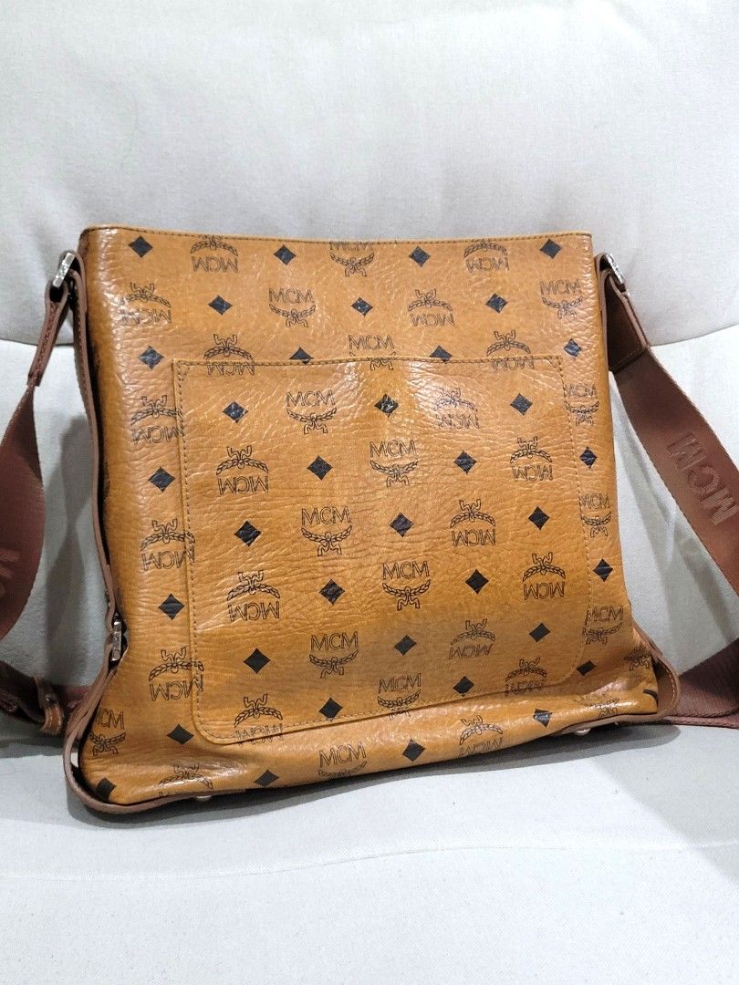 Guaranteed Authentic MCM Messenger Sling Bag (Category: Luxury Bags & Wallets) located in Antipolo. Submitted by dlolin (Listing ID 1426719357, Image 2). Description: Still super nice. Laptop and Tablet won't fit MCM messenger bag in a brown monogram pattern. Features a shoulder strap with MCM branding. Includes a main compartment and an interior pocket. The bag has a metal plate with the MCM logo and a serial number. Made in Korea..