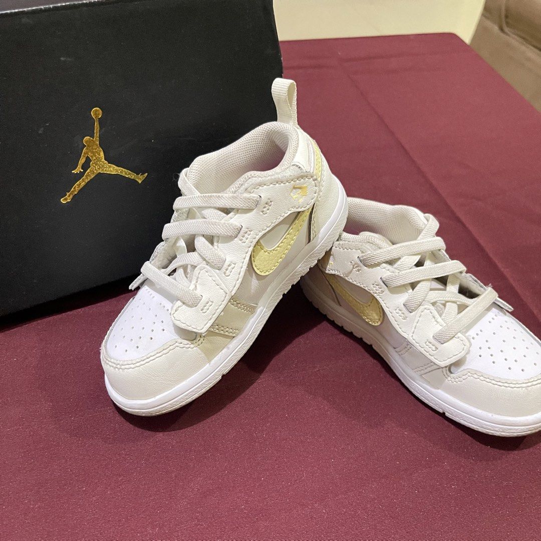 Nike Jordan 1 Low. 7C, 13-14cm (Category: Babies & Kids Fashion) located in Talavera. Submitted by acja_12 (Listing ID 1426762067, Image 1). Description: Adorable baby shoes featuring the iconic Nike Jordan design. These shoes have a white base with a yellow swoosh and accents. They come with laces and a strap for a secure fit. The shoes are presented with their original box, showcasing the Jordan logo..