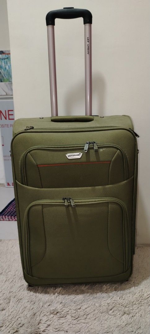 Olive Green Rolling Luggage (Category: Luggage) located in Manila. Submitted by tanyadeguzman (Listing ID 1426655680, Image 1). Description: Durable olive green rolling luggage with a retractable handle. Features multiple zippered compartments for organized packing. Includes a combination lock for added security. The interior is lined with a patterned fabric and has a small pocket. It has wheels for easy transport. The luggage has a handle on the