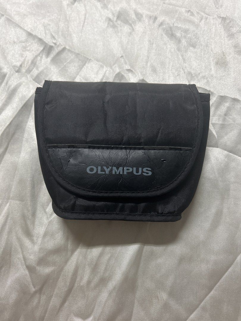 Olympus Camera Case/ for belt (Category: Camera Bags & Carriers) located in Bulacan. Submitted by ourdailybreads (Listing ID 1426667813, Image 1). Description: Black Olympus camera case. Features a flap closure with the Olympus logo. Includes a belt loop on the back for easy carrying. The interior is lined with a soft material to protect the camera..