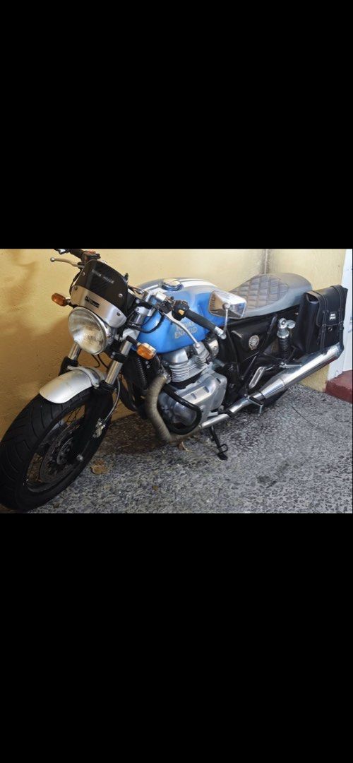 Royal Enfield Continental GT 650 (Category: Motorbikes for Sale) located in Manila. Submitted by warmwind.d05007 (Listing ID 1426637694, Image 3). Description: Royal Enfield Continental GT 650 motorcycle. Features a blue fuel tank, silver front fender, and black tires. Includes a windshield and side mirrors. The motorcycle is parked on a concrete surface..