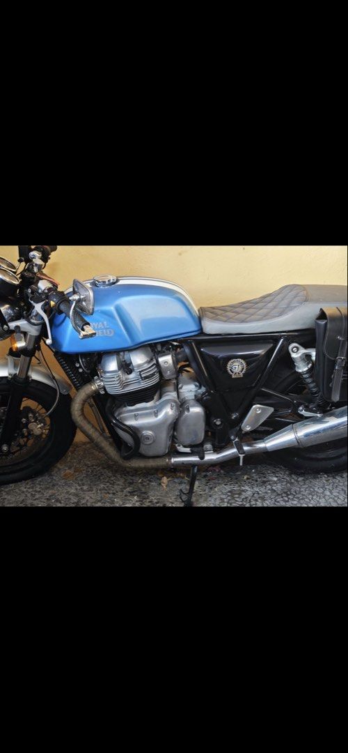 Royal Enfield Continental GT 650 (Category: Motorbikes for Sale) located in Manila. Submitted by warmwind.d05007 (Listing ID 1426637694, Image 2). Description: Royal Enfield Continental GT 650 motorcycle. Features a blue fuel tank, silver front fender, and black tires. Includes a windshield and side mirrors. The motorcycle is parked on a concrete surface..