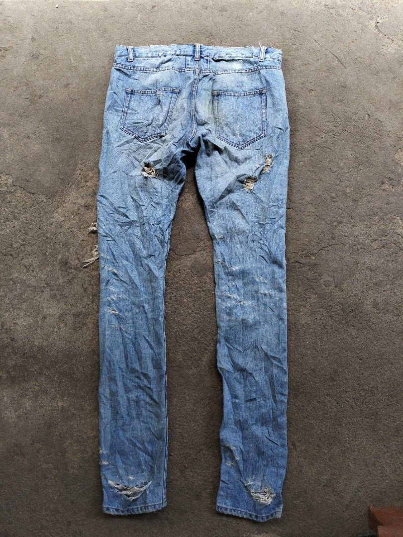 Saint Laurent Paris Distressed Jeans (Category: Luxury Apparel) located in Ilagan. Submitted by goodsanddeals-a73c28 (Listing ID 1426790872, Image 2). Description: - Distress design Authentic Saint Laurent Paris jeans. Features a light blue wash with heavy distressing throughout the front and back. Includes the Saint Laurent Paris logo on the button and leather patch. Size 32. Made in Japan. Includes the original Saint Laurent logo pin..