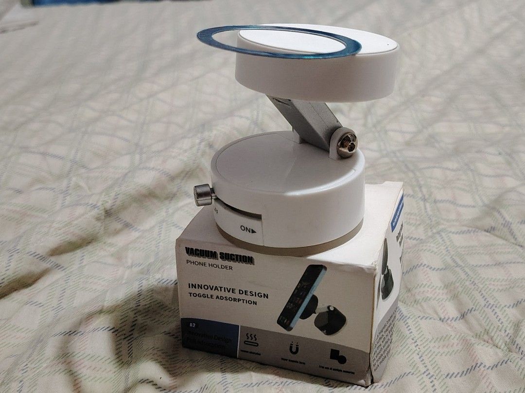 Vacuum Suction Phone Holder (Category: Mounts & Holders) located in Bulacan. Submitted by JJOSEPHA (Listing ID 1426766037, Image 3). Description: Phone holder features an innovative design with toggle adsorption. It uses vacuum suction to securely hold your phone. The holder is white and comes with a box..