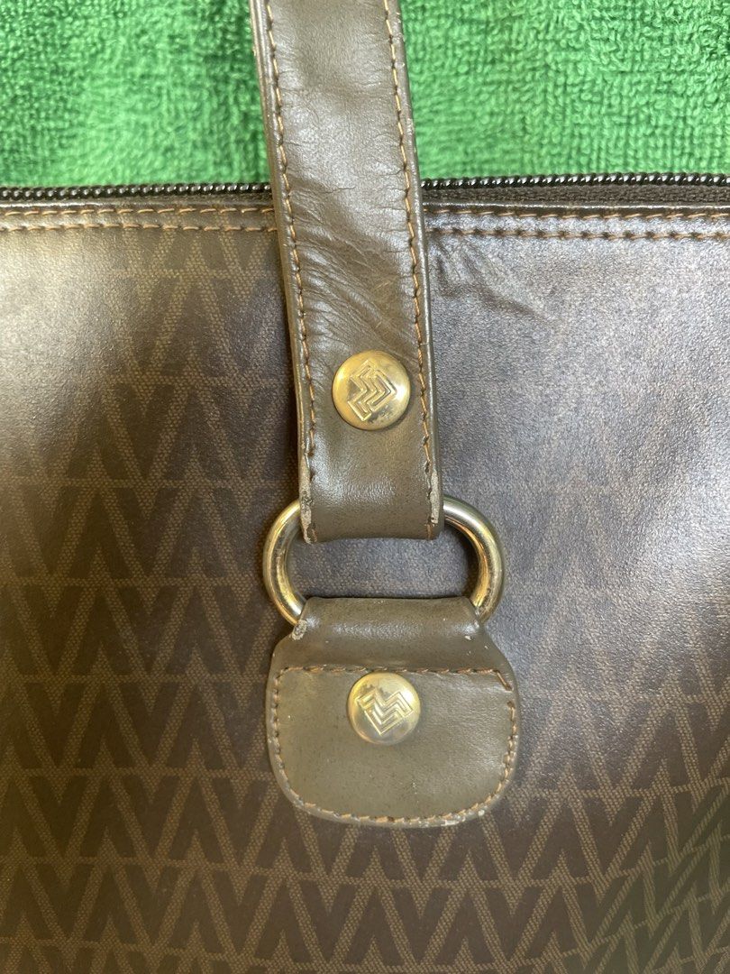 Valentino Tote Bag (Category: Luxury Bags & Wallets) located in Cavite. Submitted by msandysgoodies (Listing ID 1426647488, Image 3). Description: Flaw: starting to bubble ( not totally) Signs of usage on the handle. Fits 14-inch laptop Valentino tote bag with a brown monogram pattern. Features a top zipper closure and double top handles. The bag has a brown and olive green color scheme. The interior has a single compartment with a zipper pocket.