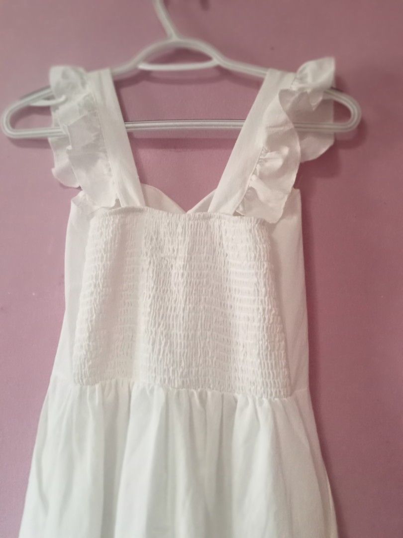 White Midi Dress with Ruffle Sleeves (Category: Dresses) located in Bulacan. Submitted by fujikko (Listing ID 1426756437, Image 2). Description: Elegant white midi dress featuring ruffle sleeves and a sweetheart neckline. The dress has a fitted bodice with smocking details and a flared skirt. It also has pockets. Perfect for a casual day out or a special occasion. Made from a lightweight fabric, it offers a comfortable fit..