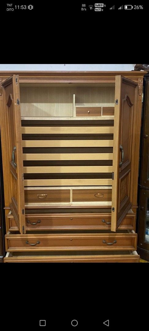 Wooden Wardrobe with Drawers (Category: Shelves, Cabinets & Racks) located in Caloocan City. Submitted by rowely_jpn (Listing ID 1426605426, Image 3). Description: Wooden wardrobe with two doors and three drawers. Features decorative carvings on the doors. The interior includes shelves and additional small drawers. Dimensions are 69 1/2" W x 50" x 17 1/2" inches. The wardrobe has handles on the doors and drawers for easy access..