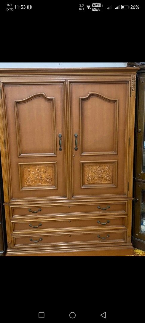 Wooden Wardrobe with Drawers (Category: Shelves, Cabinets & Racks) located in Caloocan City. Submitted by rowely_jpn (Listing ID 1426605426, Image 1). Description: Wooden wardrobe with two doors and three drawers. Features decorative carvings on the doors. The interior includes shelves and additional small drawers. Dimensions are 69 1/2" W x 50" x 17 1/2" inches. The wardrobe has handles on the doors and drawers for easy access..