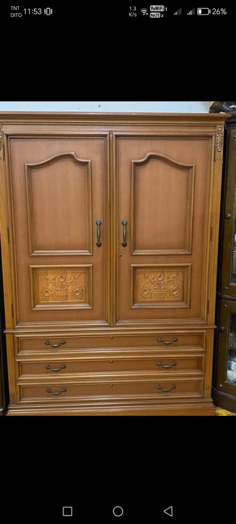 Wooden Wardrobe with Drawers (Category: Shelves, Cabinets & Racks) located in Caloocan City. Submitted by rowely_jpn (Listing ID 1426605426, Image 2). Description: Wooden wardrobe with two doors and three drawers. Features decorative carvings on the doors. The interior includes shelves and additional small drawers. Dimensions are 69 1/2" W x 50" x 17 1/2" inches. The wardrobe has handles on the doors and drawers for easy access..