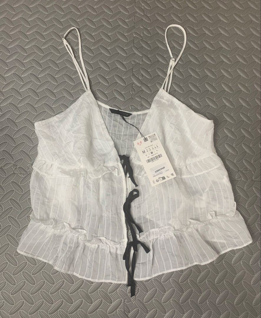 Zara M - white ruffled camisole top (Category: Sleeveless) located in Pasay City. Submitted by ella8922 (Listing ID 1426757201, Image 3). Description: -white ruffled camisole top -spaghetti straps and a tie front.