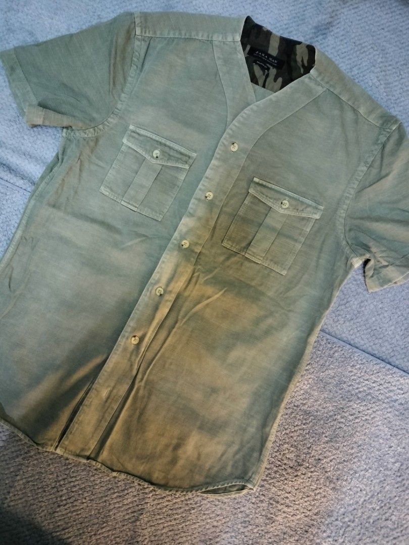 Zara Man Short Sleeve Shirt (Category: Tshirts & Polo Shirts ) located in Manila. Submitted by cyn.declutters (Listing ID 1426714075, Image 2). Description: Zara Man short sleeve shirt with a relaxed fit. Features a unique collar design with a camouflage pattern on the inside. It has two chest pockets and a button-up front. The shirt is a light green color. Size S. Dimes 20" 26.