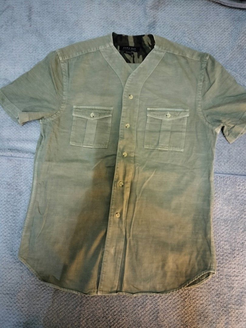 Zara Man Short Sleeve Shirt (Category: Tshirts & Polo Shirts ) located in Manila. Submitted by cyn.declutters (Listing ID 1426714075, Image 1). Description: Zara Man short sleeve shirt with a relaxed fit. Features a unique collar design with a camouflage pattern on the inside. It has two chest pockets and a button-up front. The shirt is a light green color. Size S. Dimes 20" 26.