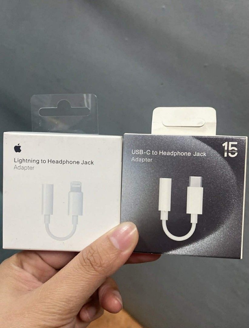 Apple Lightning to Headphone Jack Adapter & USB-C Adapter (Category: Chargers & Cables) located in Manila. Submitted by pricious (Listing ID 1426795734, Image 1). Description: Two Apple adapters are available: a Lightning to Headphone Jack Adapter and a USB-C to Headphone Jack Adapter. Both are white and appear to be new, still in their original packaging. These adapters allow you to connect your headphones to your Apple devices. Perfect for thos