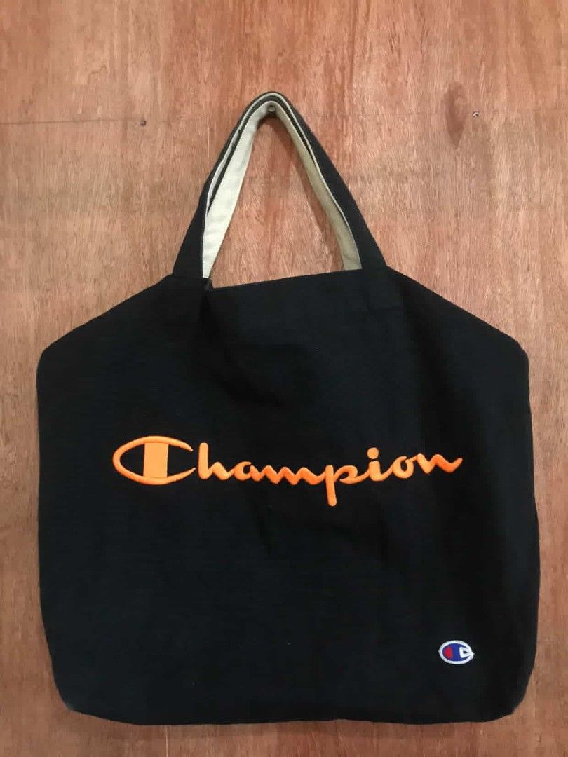 Champion Tote Bag (Category: Tote Bags) located in Manila. Submitted by ronmark (Listing ID 1426815907, Image 2). Description: Black Champion tote bag with orange embroidered logo. Features a small Champion logo on the bottom right. Includes a shoulder strap and a white interior lining.3 WAY BAG.