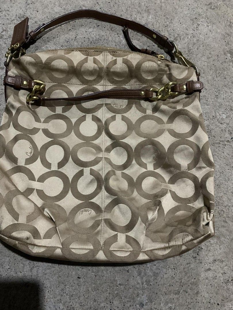 Coach Signature Shoulder Bag (Category: Luxury Bags & Wallets) located in Santo Tomas. Submitted by jadelyoidd53654 (Listing ID 1426798101, Image 2). Description: Coach shoulder bag with signature pattern. Features a brown leather strap and gold-tone hardware. Includes a Coach hang tag. The bag has a zip closure and a spacious interior. The exterior shows some signs of wear, particularly at the bottom. The bag has a classic design suitable for ev