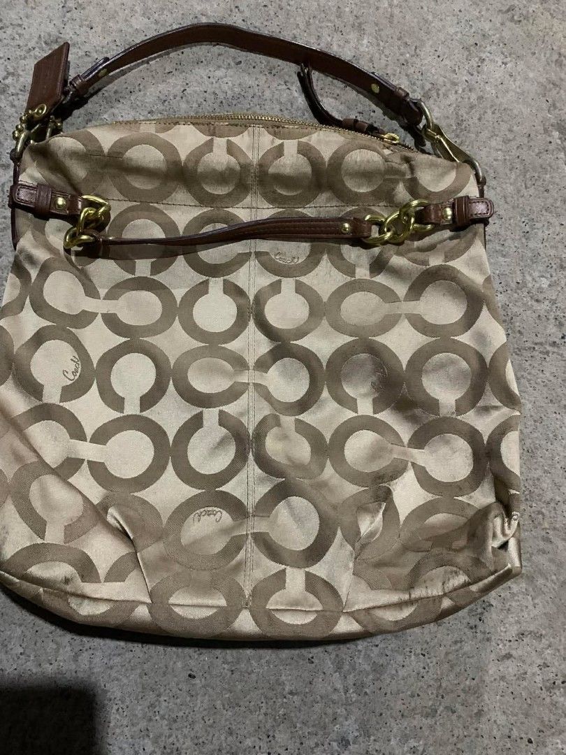 Coach Signature Shoulder Bag (Category: Luxury Bags & Wallets) located in Santo Tomas. Submitted by jadelyoidd53654 (Listing ID 1426798101, Image 1). Description: Coach shoulder bag with signature pattern. Features a brown leather strap and gold-tone hardware. Includes a Coach hang tag. The bag has a zip closure and a spacious interior. The exterior shows some signs of wear, particularly at the bottom. The bag has a classic design suitable for ev