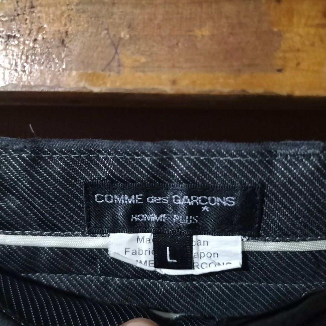 Comme des Garcons Homme Plus Gray Pants (Category: Trousers) located in Sindangan. Submitted by mix_thrift0308 (Listing ID 1426895680, Image 3). Description: Gray Comme des Garcons Homme Plus pants. Features a classic design with a straight leg cut. Made in Japan. Size L. The pants have a dark gray color. The tag shows the brand and size information. The pants have a clean and simple design, suitable for various occasions..