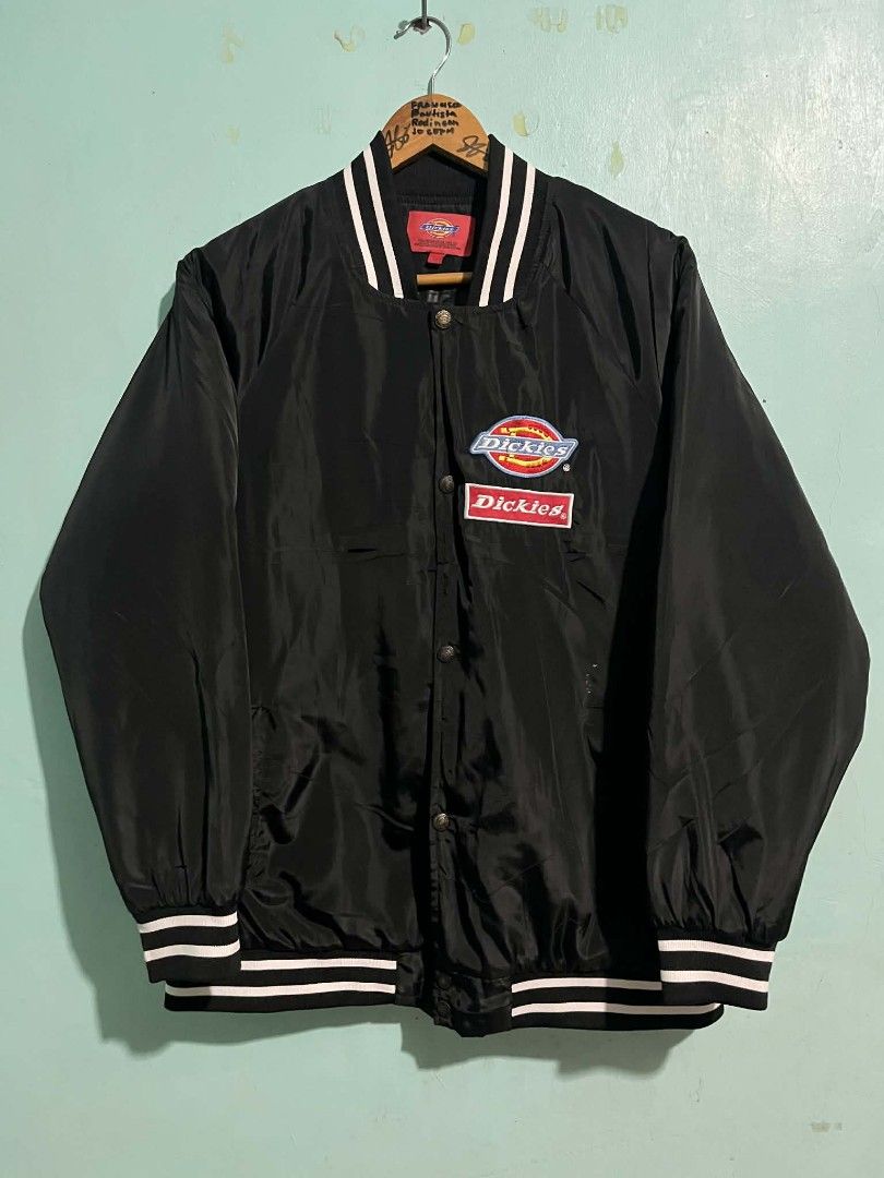Dickies Black Varsity Jacket XL (Category: Coats, Jackets and Outerwear) located in Cabanatuan. Submitted by chinithou (Listing ID 1426843612, Image 1). Description: Black Dickies varsity jacket. Features the Dickies logo on the front and back. Includes a button-up closure and striped detailing on the collar, cuffs, and hem. The jacket has an XL size tag. The interior has a quilted lining for added warmth and comfort..