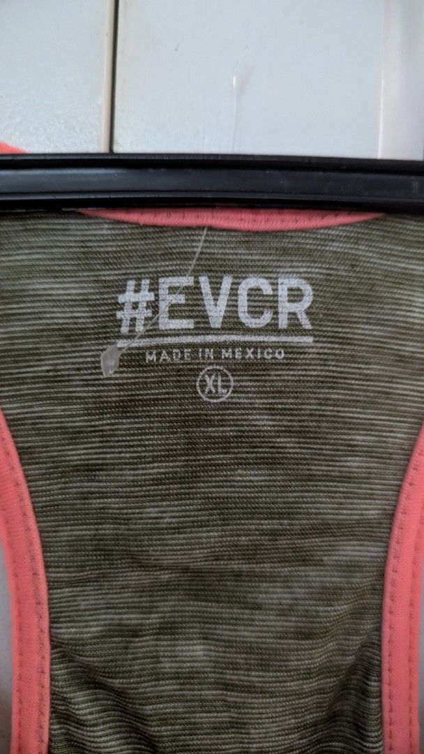 EVCR Gym Tank Top XL (Category: Activewear) located in Muntinlupa City. Submitted by lsfinds (Listing ID 1426832905, Image 3). Description: EVCR gym tank top with a racerback design. Features the text "IS IT GYM TIME YET?" on the front and "#RELENTLESS" on the back. The tank top has a green and orange color scheme. Made in Mexico..