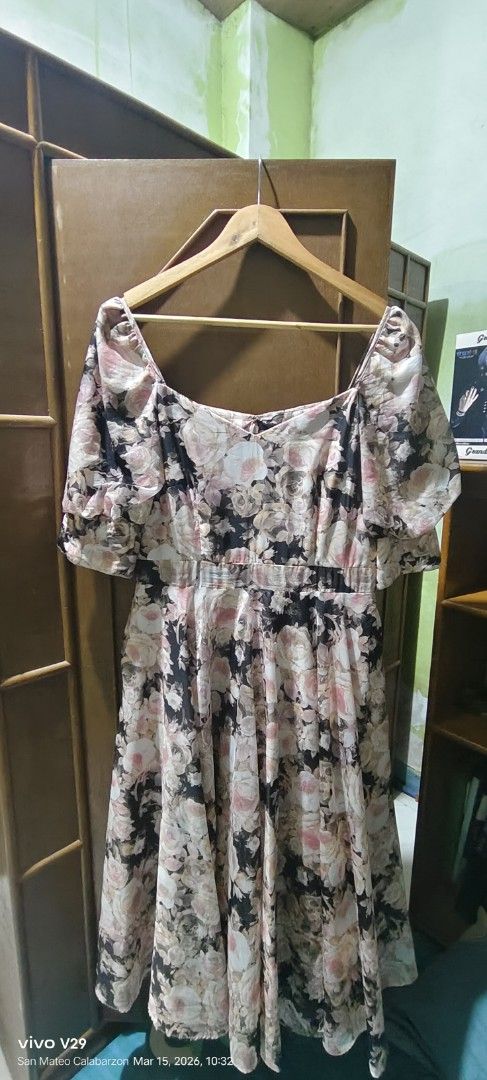 Floral Print Dress (Category: Dresses) located in Quezon City. Submitted by ak_0406 (Listing ID 1426871623, Image 1). Description: Dress features a beautiful floral print with a square neckline and short sleeves. It has an elasticated waist and a flowing skirt. The dress is hanging on a wooden hanger. The colors include black, pink, and white..