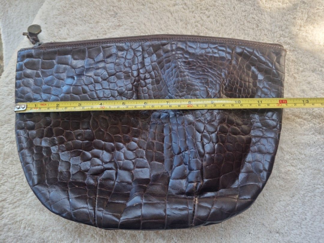 Furla Brown Crocodile Clutch (Category: Luxury Bags & Wallets) located in Baguio. Submitted by hirayadg32419 (Listing ID 1426825882, Image 3). Description: Furla clutch features a brown crocodile-embossed exterior. It has a zipper closure and a small interior pocket. The interior lining is a light brown suede. The zipper pull has an "Italy" tag..
