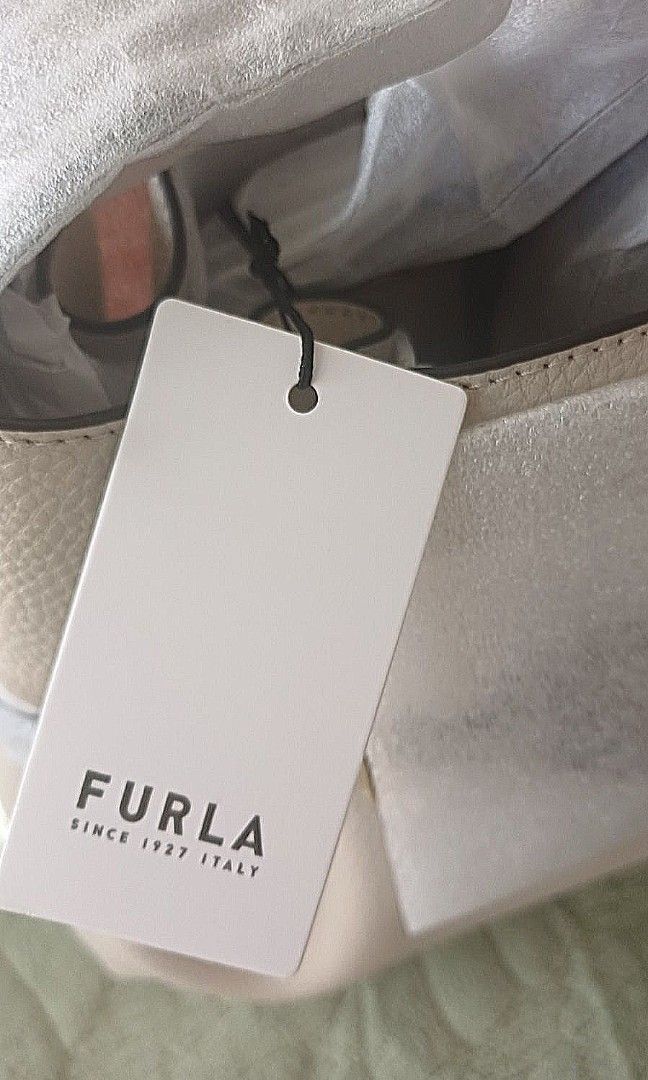 Furla Bucket Bag with Shoulder Strap (Category: Luxury Bags & Wallets) located in Las Pinas. Submitted by ajbash (Listing ID 1426871861, Image 3). Description: Elegant Furla bucket bag. Features a neutral color with a blue stripe detail and gold-tone hardware. Includes a shoulder strap. Comes with original tags and dust bag. Perfect for everyday use or special occasions. A stylish and versatile addition to any wardrobe..