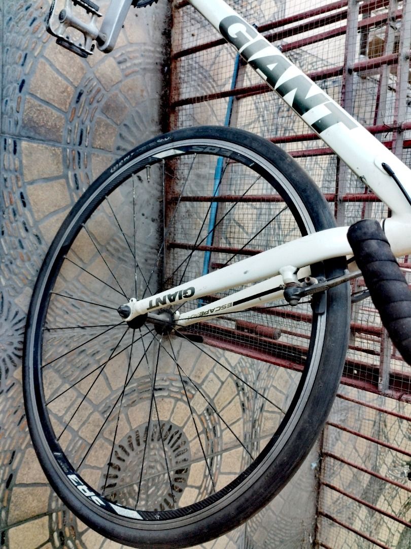 Giant Road Bike (Category: Bicycles) located in Mandaluyong City. Submitted by josephbatulan (Listing ID 1426884052, Image 3). Description: White Giant road bike with black handlebars and seat. Features Shimano Altus rear derailleur. Includes black tires and a black and silver crankset. The bike has a white frame with green and black accents. The bike has drop handlebars..