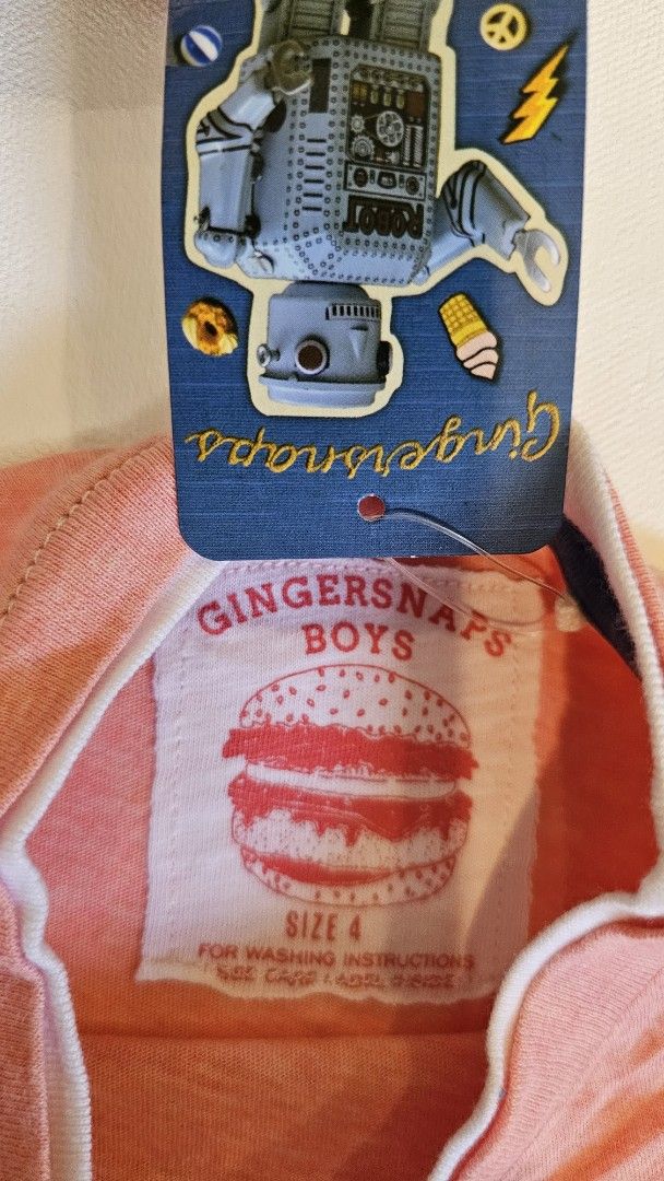 Gingersnaps Boys T-shirt Size 4 (Category: Babies & Kids Fashion) located in Quezon. Submitted by cgmhe (Listing ID 1426871697, Image 2). Description: Gingersnaps Boys T-shirt in size 4. Made in the Philippines. Features a crew neck with white trim. The shirt is a light coral color. Made of 100% cotton. Includes the original tag with a robot design..
