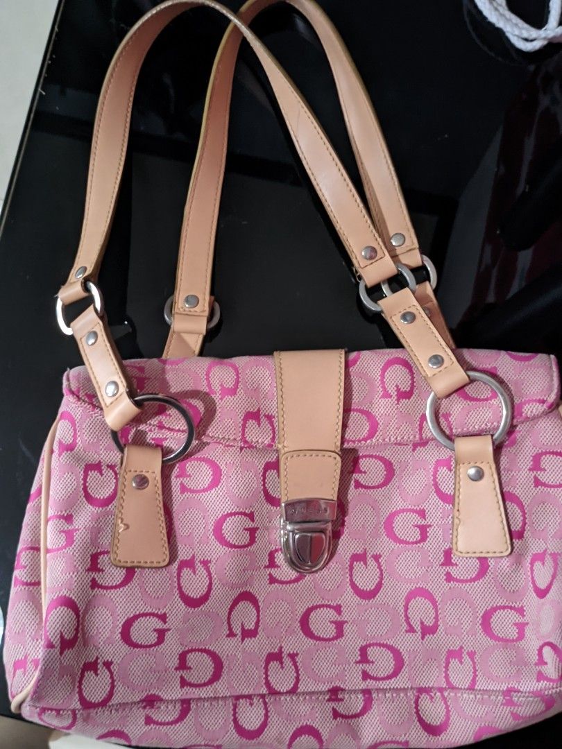 Vintage bag Guess Pink (Category: Luxury Bags & Wallets) located in Manila. Submitted by happydragon.eb63f5 (Listing ID 1426811061, Image 1). Description: Pink Guess handbag with a repeating 'G' pattern. Features a top handle design with beige leather straps and silver hardware. Includes a front zipper pocket and a main compartment with a pink satin lining. The bag has a magnetic clasp closure. The interior has a pocket with the 'G' pattern..