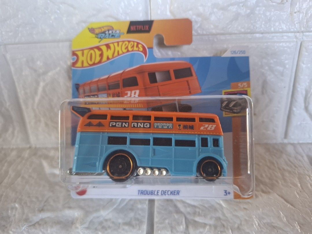 Hot Wheels Trouble Decker Netflix (Category: Vehicle & Diecast Models) located in Narvacan. Submitted by jigger85_2ndaccount (Listing ID 1426815873, Image 1). Description: Hot Wheels Trouble Decker is a vibrant blue and orange bus. It features the word "PENANG" on the side and the number "28". The car is part of the Netflix series and comes in its original packaging. It is a 5/5 model..