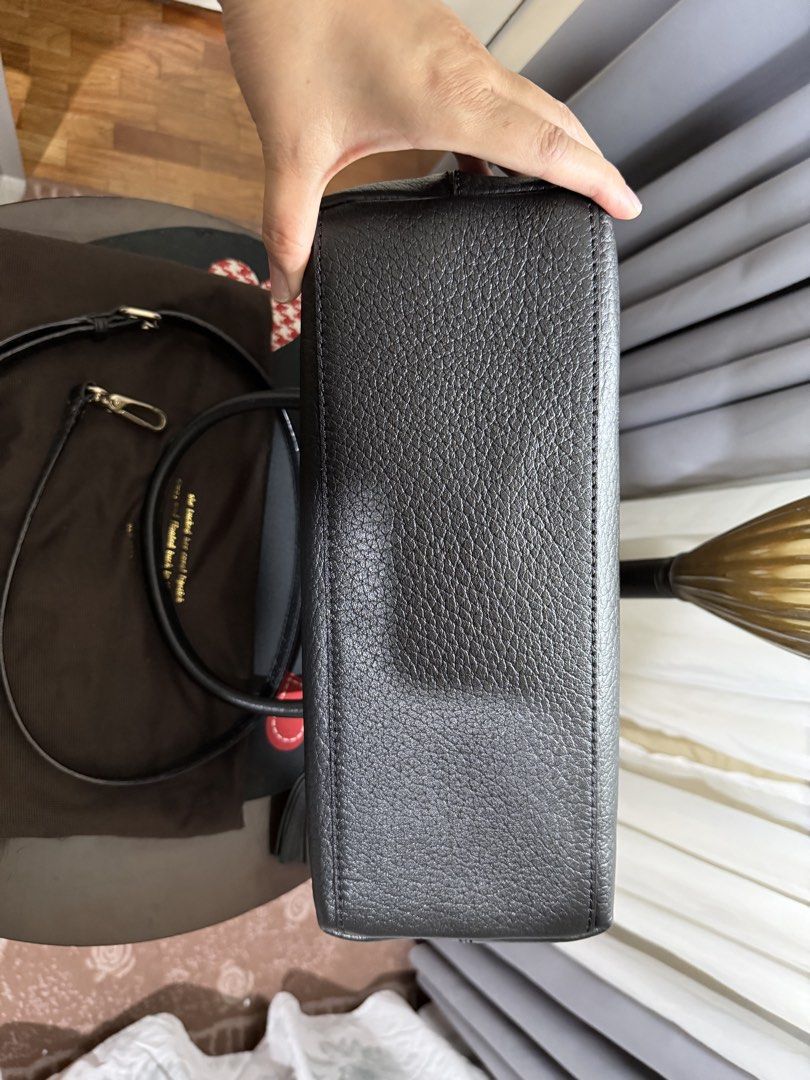 Kate Spade New York Handbag (Category: Luxury Bags & Wallets) located in Marikina City. Submitted by stuffs23 (Listing ID 1426898186, Image 3). Description: Kate Spade handbag features a cream and black color scheme. It has a top handle and a detachable shoulder strap. The interior has a striped lining and a small pocket. A tassel hangs from the zipper. Includes a dust bag..