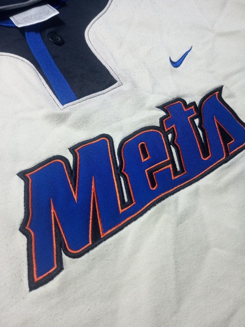 Nike New York Mets Baseball Jersey (Category: Tshirts & Polo Shirts ) located in Davao. Submitted by lordpabito71094 (Listing ID 1426872710, Image 2). Description: Authentic Nike baseball jersey featuring the New York Mets. The jersey has a white body with black sleeves and blue accents. The Mets logo is prominently displayed on the front, and the Nike logo is visible. The back of the jersey features the Mets logo. Made in Indonesia..