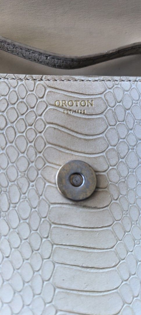 Oroton (Category: Luxury Bags & Wallets) located in Cagayan de Oro. Submitted by tommygurl1218 (Listing ID 1426871416, Image 2). Description: Elegant Oroton handbag featuring a snakeskin pattern. It has a unique bamboo handle and a magnetic closure. The interior includes a zipper. The bag is a neutral color, suitable for various outfits. The Oroton logo is visible on the exterior and interior. With minimal sign of use.. .