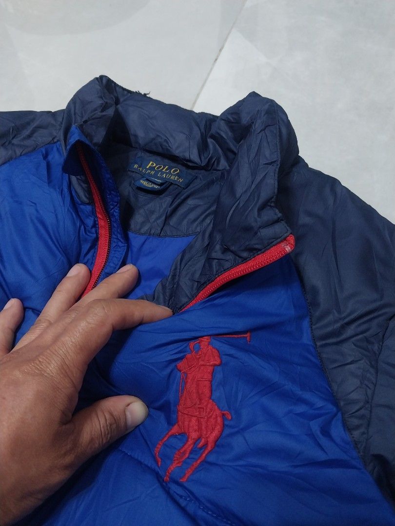 Polo Ralph Lauren Blue Jacket (Category: Coats, Jackets and Outerwear) located in Malaybalay. Submitted by markdaumar08466 (Listing ID 1426849946, Image 3). Description: Jacket features a vibrant blue body with navy blue sleeves. It has a red zipper and two front pockets. The Polo Ralph Lauren logo is prominently displayed on the chest. The tag is visible in the image..