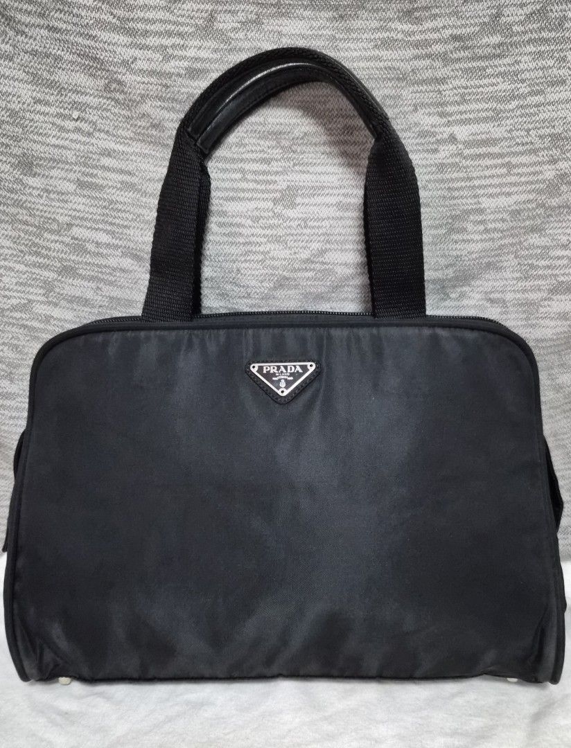 Preloved Prada Tessuto Nylon top-handle bag (Category: Luxury Bags & Wallets) located in Quezon City. Submitted by marya_s (Listing ID 1426824661, Image 1). Description: if namamahalan pa sa 9k wag na po mag Prada Authentic Prada handbag in black. Features a top handle design with a zip closure. Includes a lock and keys. The interior has a Prada logo. The bag has a classic shape with a nylon exterior. Includes a dust bag. The bag has metal feet o