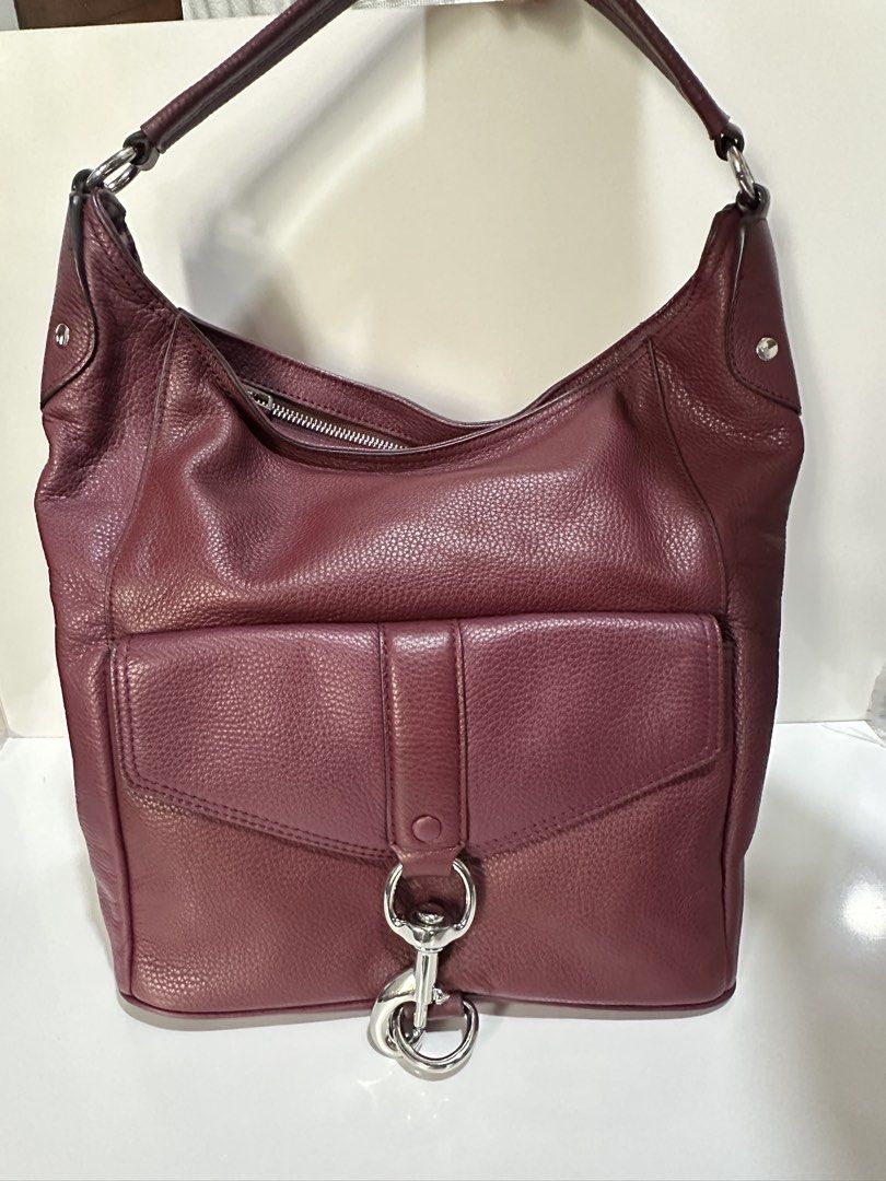 Rebecca Minkoff Burgundy Leather Hobo Bag (Category: Luxury Bags & Wallets) located in Makati City. Submitted by gnarlyb (Listing ID 1426811199, Image 2). Description: Burgundy leather hobo bag by Rebecca Minkoff. Features a front pocket with a flap closure and a silver-tone clasp. The bag has a top zipper closure and a single shoulder strap. The leather has a pebbled texture. A small silver-tone brand plate is visible on the bag. excellent condi