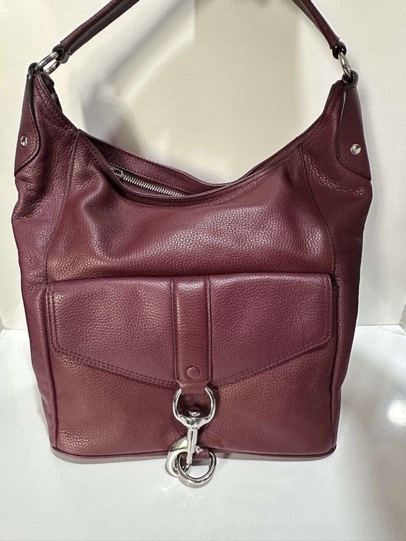 Rebecca Minkoff Burgundy Leather Hobo Bag (Category: Luxury Bags & Wallets) located in Makati City. Submitted by gnarlyb (Listing ID 1426811199, Image 3). Description: Burgundy leather hobo bag by Rebecca Minkoff. Features a front pocket with a flap closure and a silver-tone clasp. The bag has a top zipper closure and a single shoulder strap. The leather has a pebbled texture. A small silver-tone brand plate is visible on the bag. excellent condi