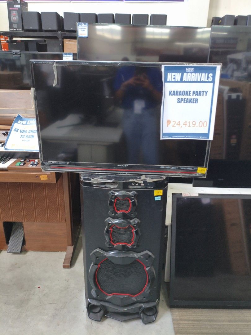 Sharp Karaoke Party Speaker (Category: Soundbars, Speakers & Amplifiers) located in Manila. Submitted by hmrgrace5. (Listing ID 1426821816, Image 1). Description: Sharp Karaoke Party Speaker with a built-in speaker and a TV. The price is ₱24,419.00. It is a new arrival from HMR Trading Haus. The speaker has a black body with red accents. The TV is mounted on top of the speaker..