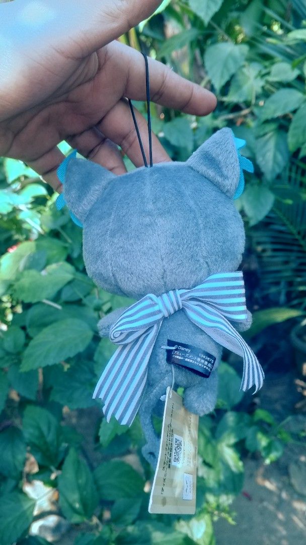 Twisted Wonderland Grim Charm Plushie (Category: Plushies & Soft Toys) located in Mamburao. Submitted by rogerhabbitz (Listing ID 1426874164, Image 2). Description: Adorable plushie featuring a character from Twisted Wonderland. It has a gray body with blue accents on the ears and eyes. The plushie has a bow and a tag attached. It is a cute collectible item..