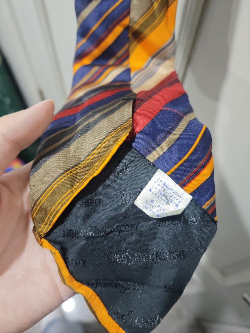 Yves Saint Laurent Striped Tie (Category: Ties) located in Iloilo. Submitted by declutterpm2 (Listing ID 1426858004, Image 3). Description: Stylish Yves Saint Laurent tie featuring a vibrant striped design. The tie showcases a mix of colors including blue, yellow, red, and beige. The brand's logo is visible on the back of the tie. A classic accessory to elevate any outfit..
