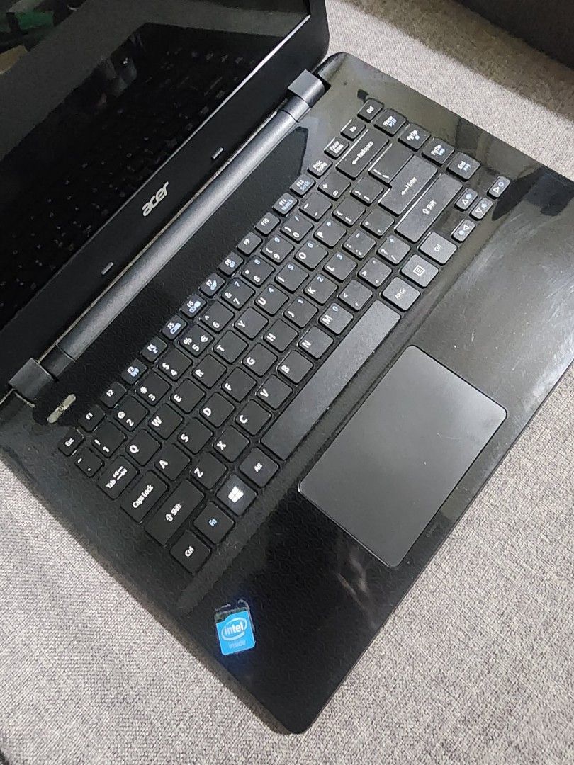 Acer ES-411 Laptop (Category: Laptops & Notebooks) located in Quezon City. Submitted by sebbysprelovedgoods (Listing ID 1426974238, Image 3). Description: Acer ES-411 laptop with Intel processor. Includes the original charger. The laptop has stickers on the lid. The model number is ES-411-C3K3. Manufactured in 2014. The laptop has a black body and keyboard. The screen is open in the images. The laptop has a VGA port, Ethernet port, HDMI port, and
